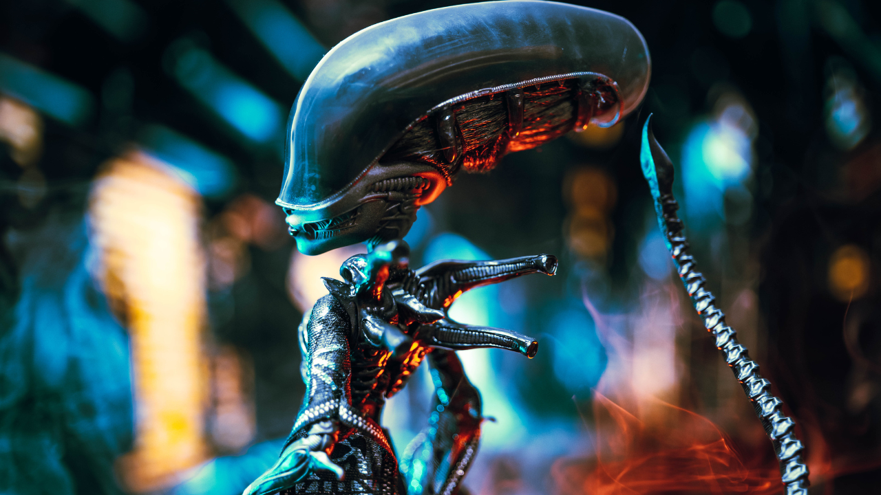 Dentro de su diseño encontramos su escultura facial y corporal detallada inspirada en el Xenomorfo y un vestido negro translúcido con detalles que evocan el exoesqueleto de la criatura.